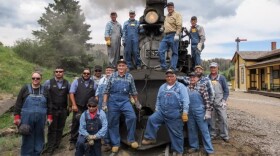 The Cumbres & Toltec Scenic Railroad engineer and fireman school poses with instructors in front of the Engine 487 at the summit of Cumbres Pass in Colorado. (Jenny Brundin/CPR News)