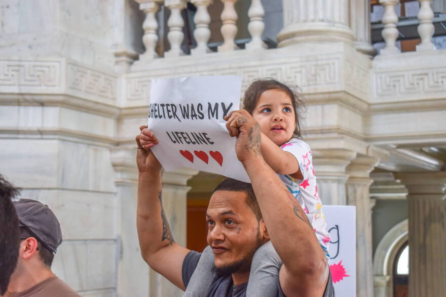 Mia Negron, 2, sits atop her father Luis’ shoulders at a State House rally on May 27, 2025. The family became unhoused when Mia was an infant in 2023.