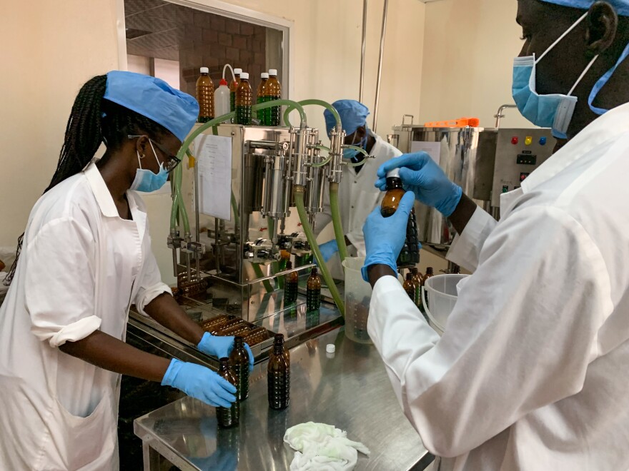 Workers at a government-sponsored facility in Kampala bottle liquid morphine. The solution essentially consists of morphine powder mixed with water. Uganda provides it to patients for free.