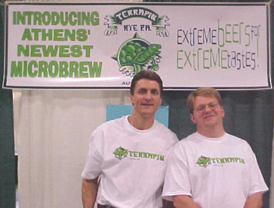 Two men wearing Terrapin T-shirts pose in front of a promotional banner introducing the Athens microbrewery.