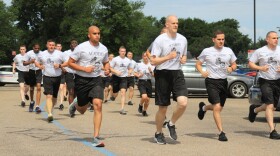 The newest class of police recruits running through the police academy parking lot