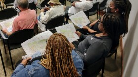 A group of people look over the schematics for the Smithville Revitalization Plan at June 7 informational meeting in Cornelius. The plan seeks to redevelop an aging historically Black neighborhood. The plans were developed by local Smithville residents. and the city of Cornelius will vote on the plans Monday.