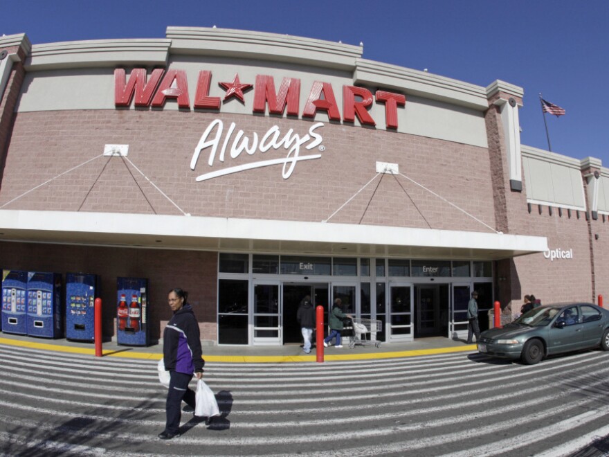A woman makes her way out of a Wal-Mart store in Oakland, Calif. Wal-Mart Stores Inc. reported a 27 percent increase in fourth-quarter net income as the world's largest retailer benefited from cost-cutting and strong sales overseas.