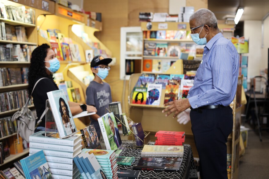 Eso Won Books has been selling popular and less-known titles about race, according to Fugate (right), who helps Esteban Zaragoza, 11, and his mom, Karina Murillo, find a book on the Black Panthers.