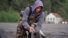 Nathan Brooks sprays seawater into a small pit on the beach near Sheep Creek in Juneau on May 15, 2019. It's part of his gold dredging rig. (Photo by Jeremy Hsieh/KTOO)