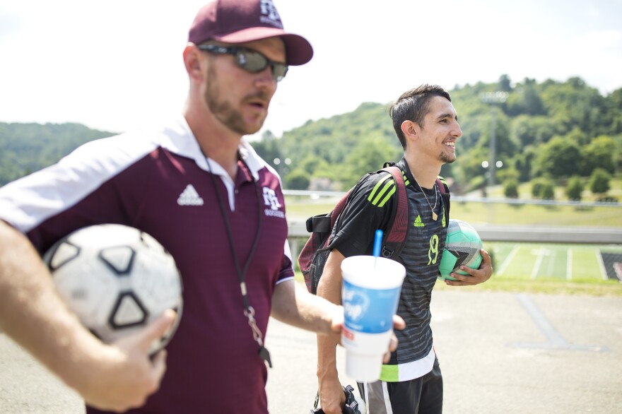 Ricardo Osuna, right, who graduated from high school this spring, and head soccer coach Troy Barkley, left, leave the Galax High School field. Osuna helped to lead the school's soccer team to the state championship title the past two years. Barkley credits the sheer love of soccer that his Hispanic players have as a contributing factor to the team's success.