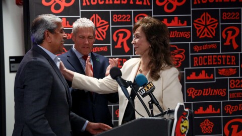 Red Wings President and CEO Naomi Silver thanks Faheem Masood, president and CEO of ESL Federal Credit Union, during a news conference on Tuesday, Feb. 10, 2026, announcing ESL Ballpark as the new name of the baseball stadium. In the background, Monroe County Executive Adam Bello applauds. The naming rights agreement will run an initial 10-year term with options to extend up to 30 years.