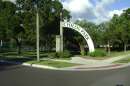 Entrance of the park, with many trees around and a circular concrete frame that says "childs park."