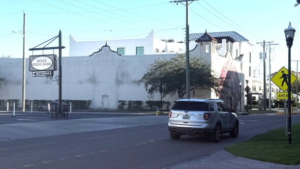 a silver SUV drives south down south howard avenue in front of bern's steak house