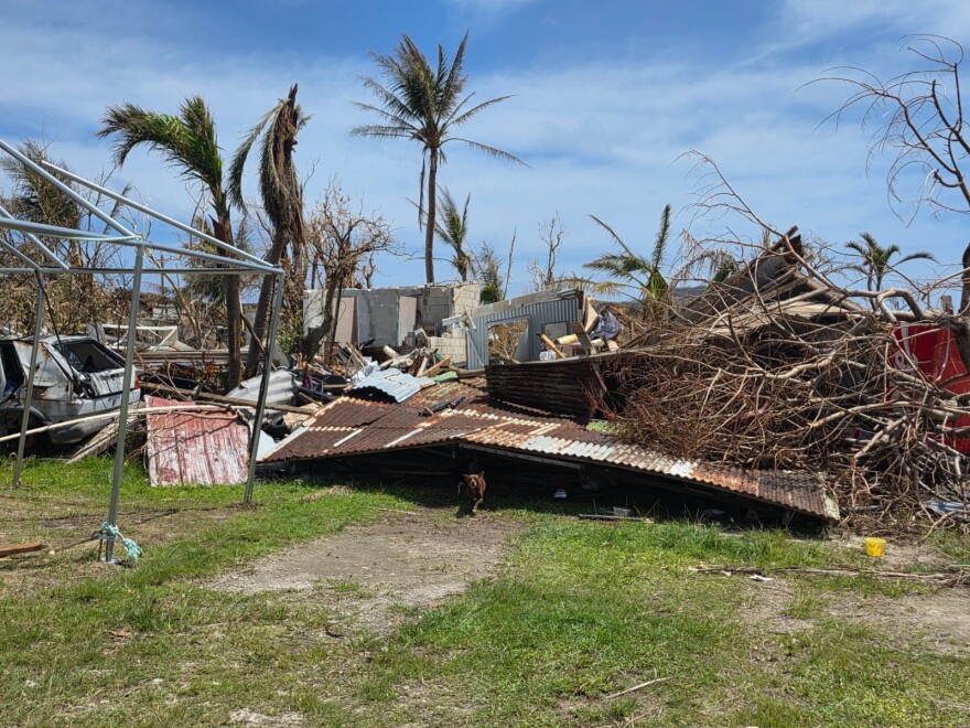 A tin‑and‑wood house lies in ruins after Super Typhoon Bavi’s landfall on Rota on July 6, leaving twisted metal, uprooted trees, and shattered walls in its wake.