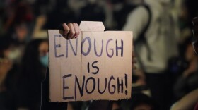A person holds up a sign as protesters kneel on Canal St. during a demonstration over the death of George Floyd in police custody in Minneapolis on May 31, 2020 in New York.(Bryan R. Smith / AFP via Getty Images)