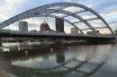 The Interstate 490 bridge is shown over the Genesee River with the downtown Rochester skyline seen through the arches.