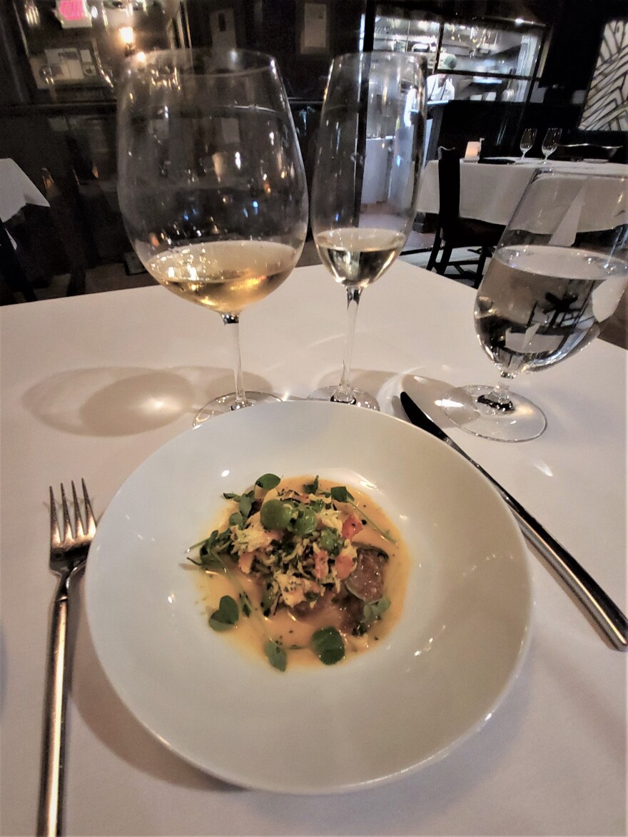 Executive Chef Andy Blanton works in the kitchen while the second course is brought to the table: Golden Alaskan King Crab with morels, fava beans, heirloom tomatoes, saffron, lemon basil oil and pea sprouts.