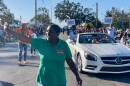 Dot Inman-Johnson waves as she walks in a parade