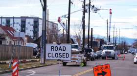 Xcel Energy workers work to repair power lines on a street closed after hurricane-force winds whipped through the metropolitan area and interrupted service to residents, Thursday, Dec. 18, 2025, in Denver.