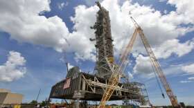 A swing test of the Orion crew access arm, topmost umbilical, is in progress on the mobile launcher at NASA's Kennedy Space Center in Florida, on Aug. 21, 2018.