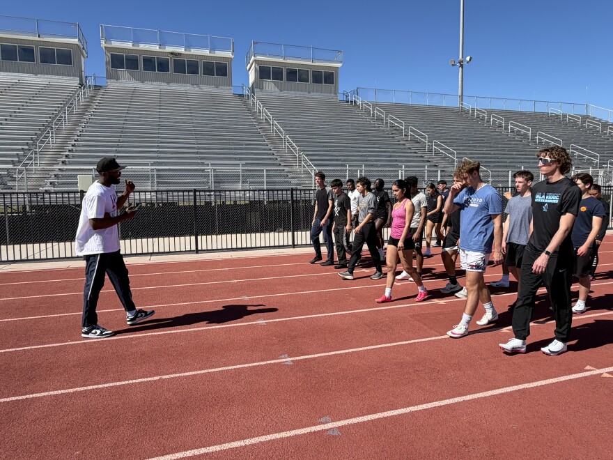 3-time Olympic gold medalist Lashawn Merritt, left, gives advice to Yuma high school track athletes during a clinic at Gila Ridge High School in Yuma on Saturday, Feb. 21, 2026.