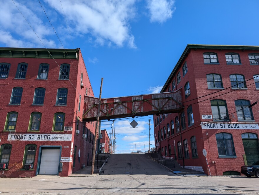 Two industrial buildings from the the 1850s with a bridge connecting them across the street