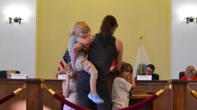Jennifer Eagle, with her three children, speaks at the library board of trustees meeting