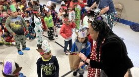Superintendent Ebony Johnson hands a Springdale Elementary student a gift bag on Friday, Dec. 15, 2023.