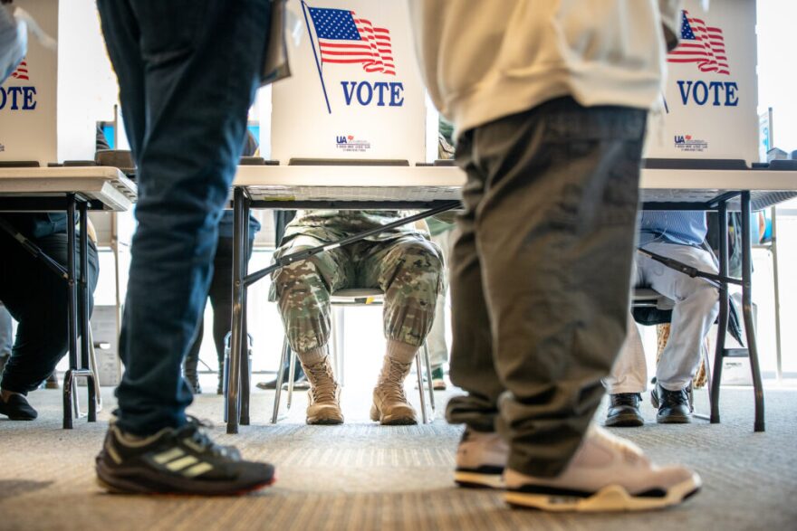 FILE - Voters on Election Day, including one in military uniform, at the busy Centre Point polling station in Aurora, Nov. 5, 2024.
