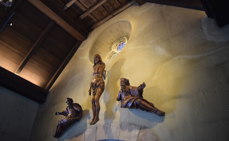 The carved wood art piece is from the 1700s from Florence, Italy. It would have originally been painted bright colors, and Christ would have been on the cross, but that was destroyed in the bombing raid in 1945. This piece is one of Dr. Jennifer Vanderhayden's favorite features of the chapel. "If you look at the shadow, it looks like angel wings and that fits in so well with Joan of Arc," she says.