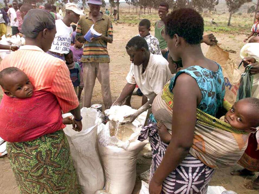 In this Aug. 27, 1998, photo, families from Rwanda await distribution of food at the Kingtele refugee camp near Brazzaville, Congo. At the time, the camp hosted more than 4,000 Hutu refugees who feared the arrival of Tutsi rebels on the other side of the Congo River.