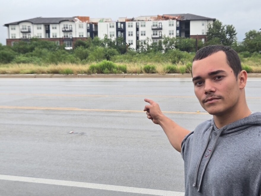 Noah points to The Oasis San Antonio apartments July 15, 2026. His building sustained damage from a tornado that touched down in the early morning hours.