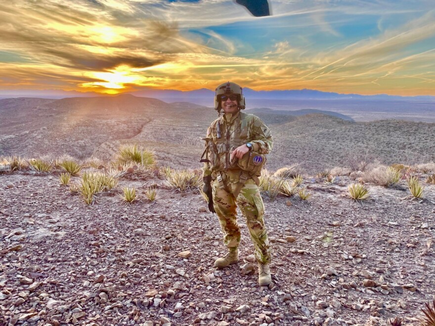 A photo from a training mission in El Paso before Shukla went to residency. He stands in the desert, wearing Army fatigues in front of a sunset.