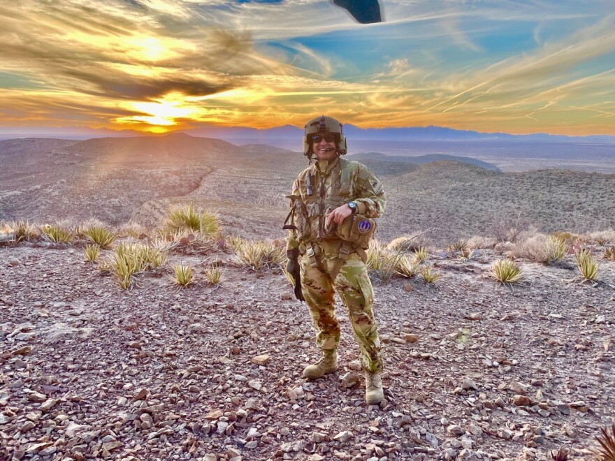  A photo from a training mission in El Paso before Shukla went to residency. He stands in the desert, wearing Army fatigues in front of a sunset. 