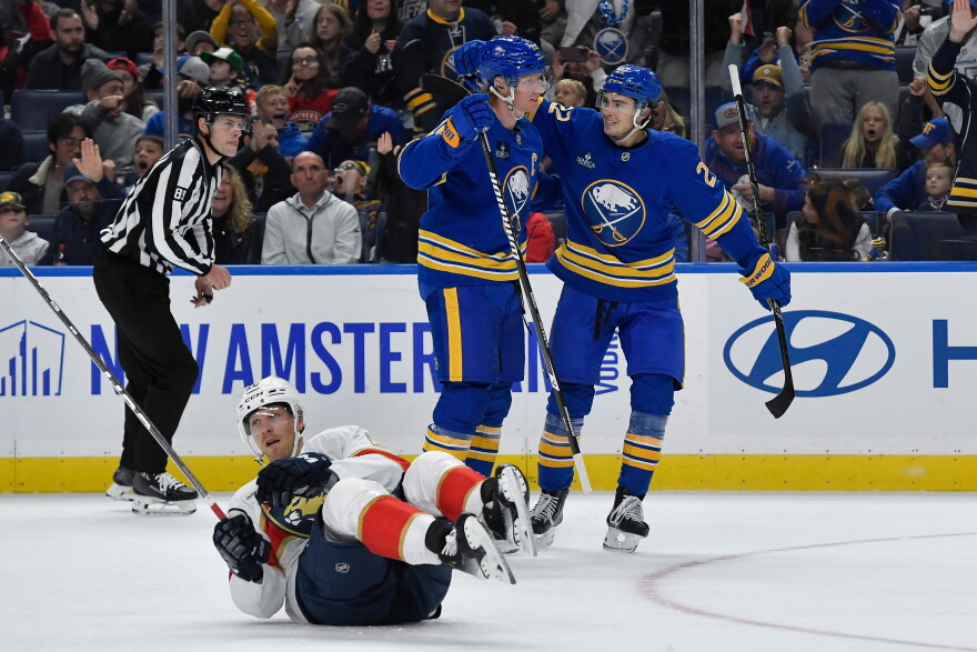 Buffalo Sabres defenseman Rasmus Dahlin, center, celebrates with right wing Jack Quinn, right, after scoring as Florida Panthers center Lars Eller (20) lays on the ice during the first period of an NHL hockey game Monday, Oct. 12, 2026, in Buffalo, N.Y.