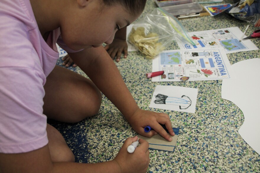 A group of students at Heatherstone Elementary create a collaged jersey about Argentina, one of the teams coming to Kansas City for the World Cup.