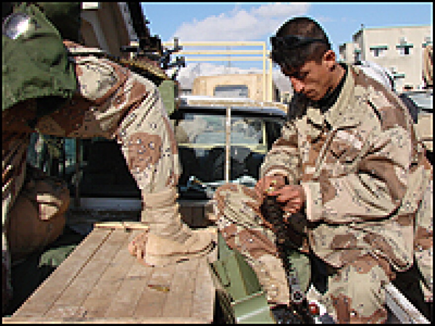 A Kurdish soldier loads the ammunition belt of his machine gun.