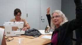 Volunteer sewist Charlotte Duruisseau works on a project with clinic attendee Debbie Sommer