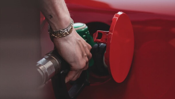 A person pumping gas into a vehicle.