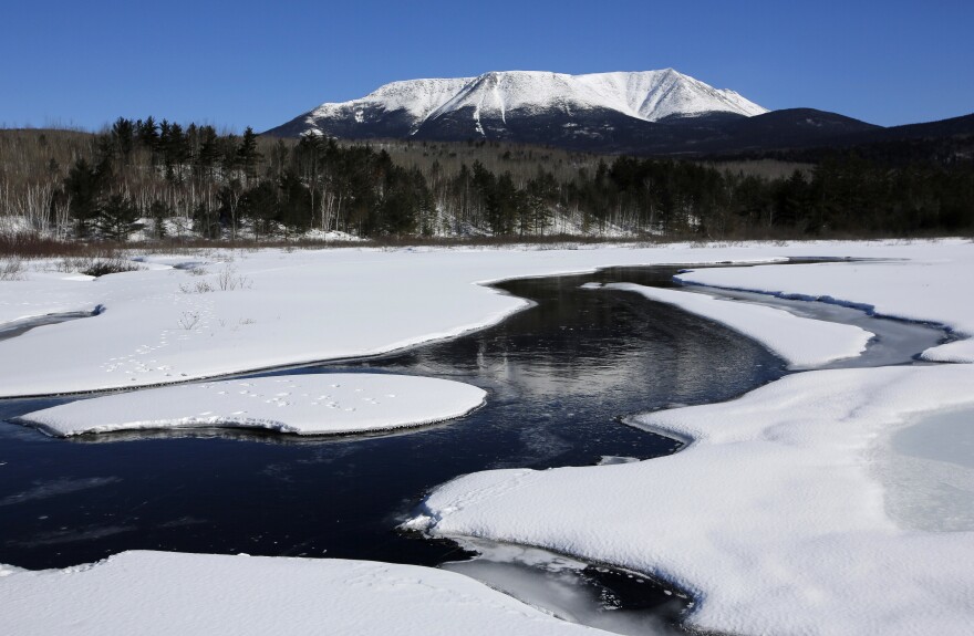 Mt. Katahdin looms over the forest on a rare clear skies, Sunday, March 18, 2018, in Baxter State Park near Millinocket, Maine, Sunday. The 5,269-foot peak attracts winter climbing enthusiasts seeking a challenge on the state's highest mountain.