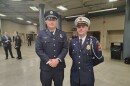 Two men in firefighter attire pose for a photo