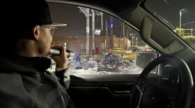 Vincent Williams shines flashlight on dump pile at 26th and Peralta in West Oakland
