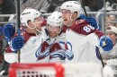 Three Colorado Avalanche players celebrate on ice.