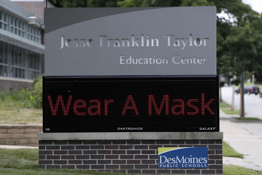 A sign displaying "wear a mask" sits in front of the Jesse Franklin Taylor Education Center, Wednesday, July 29, 2020, in Des Moines, Iowa. (AP Photo/Charlie Neibergall)