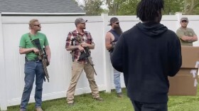 This June, 1, 2020, image from video provided by Alissa Murray shows demonstrators protesting police brutality and racism encountering a line of armed bystanders as they march in Crown Point, Ind. Crown Point Police Chief Pete Land said the armed bystanders are protected under state law.