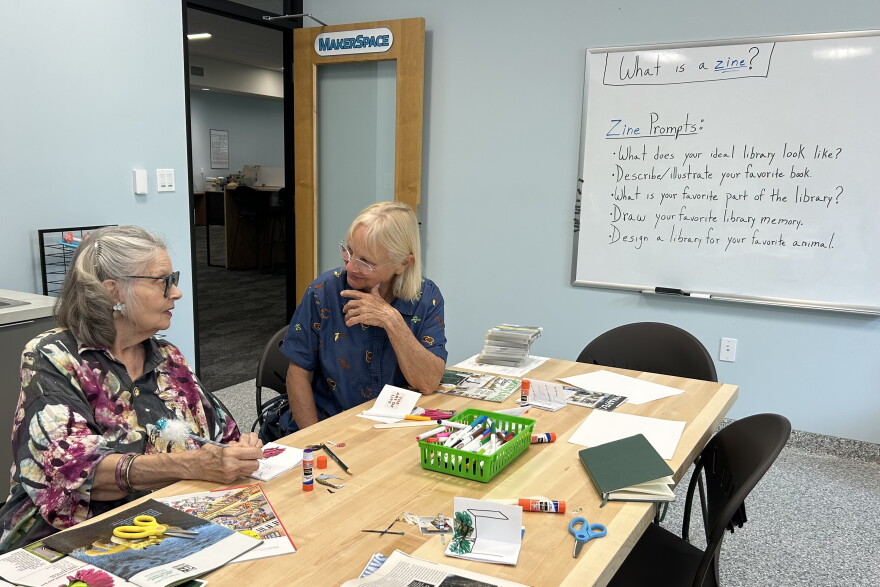 Meredith Henry (left) and Beverly Gill attend a zine-making workshop at the Hawthorne library. Henry had served Gill behind the library counter for over 20 years, and now they craft as friends. "It is gratifying to be an integral part of people's routines and goals and life trajectories," Henry said. (Molly Seghi/WUFT News)