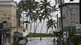 A man crosses the road as Hurricane Nolo sits nearby Saturday, Sept. 26, 2026, in Hilo, Hawaiʻi.