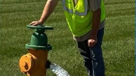 An Evansville Water and Sewer Utility worker opens a fire hydrant to flush the water lines
