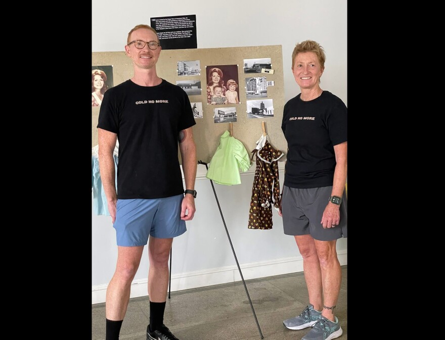 James Sanders (left) and Dena Sanders (right), the children of Janis Sanders, stand in front of a poster board with family photos and baby clothes at an event held in Niles on July 19, 2025. Now 52 and 55, the siblings continue to search for answers about their mother's disappearance and advocate for investigative efforts around cold cases in Michigan.