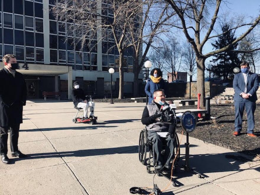 Doug Hovey with Independent Living Inc. speaks of the need for Wi-Fi service for state-run homes for New Yorkers with disabilities. At left is Sen. James Skoufis; behind him and to the right is Alex Thompson of the New York Association on Independent Living and Sens. Samra Brouck and John Mannion. 