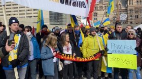 A group of demonstrators, holding signs in Ukrainian and in English, saying "PRAY FOR UKRAINE" and "STOP WAR."