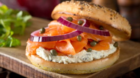 A delicious toasted bagel with smoked salmon, cream cheese, capers, and red onion.
