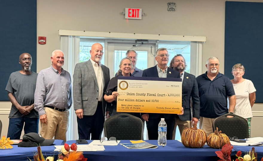 Officials hold a ceremonial check after receiving word of $16 million in state funding to help pay for a water treatment plant in Sturgis, KY