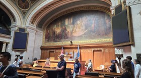 Tourists of the Wisconsin Legislature walk through the Assembly chamber where state laws are passed.